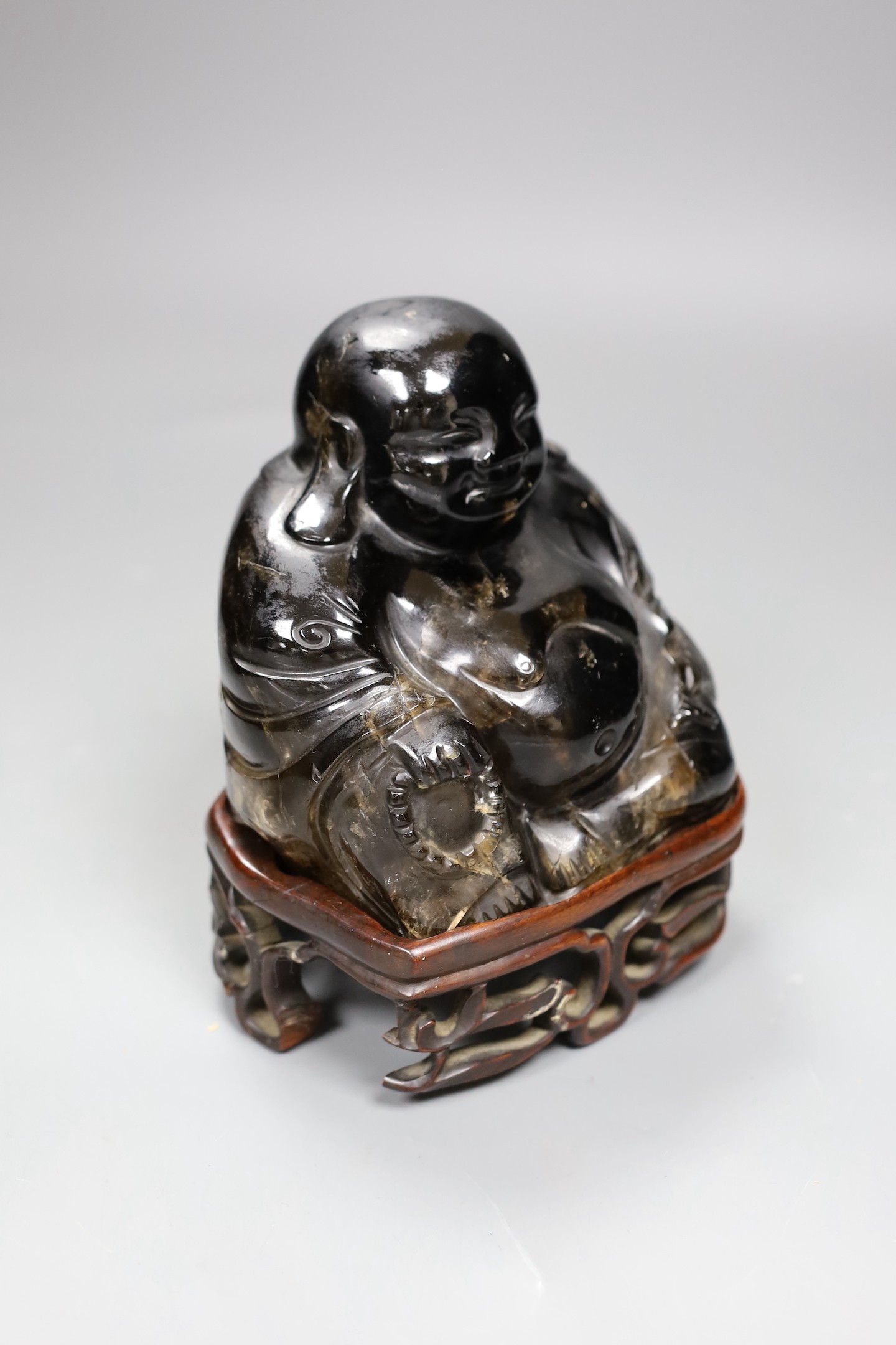 A large Chinese smoky quartz figure of Budai, 17cm tall including wood stand